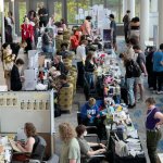 lined up artist booths with shoppers looking at products and talking with artists. on September 26, 2026